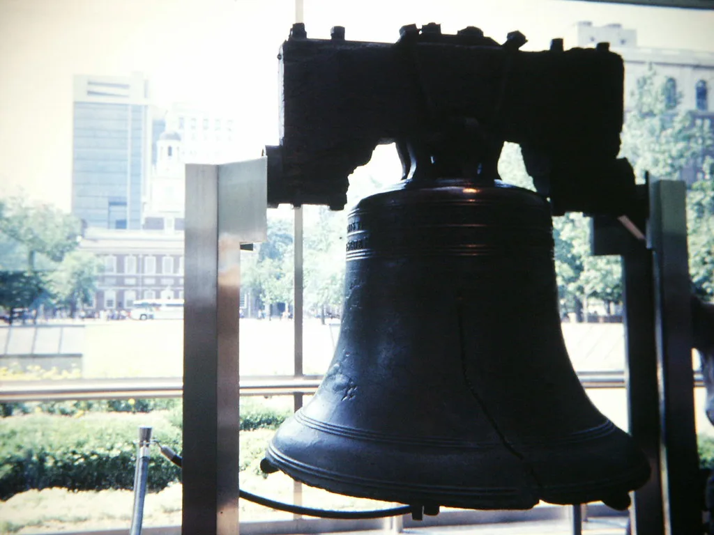 The Liberty Bell displayed in its pavilion with Independence Hall visible across the lawn
