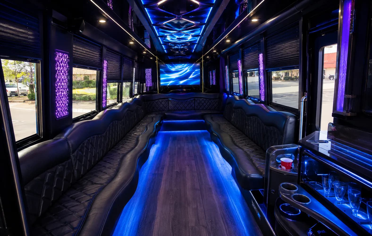 Party bus interior with wraparound seating and accent lighting